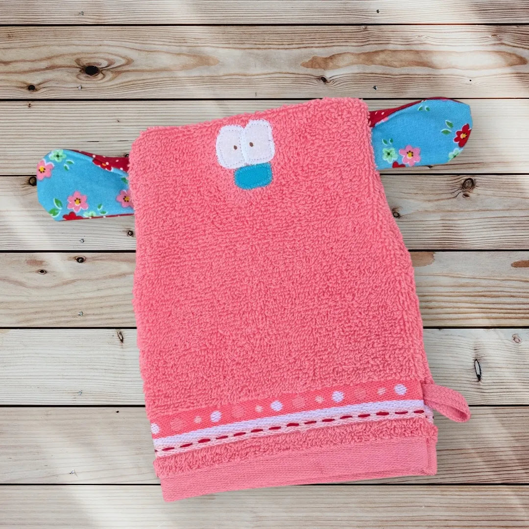 Rosa Waschhandschuh in Form eines lustigen Monsterchens mit großen Augen, bunter Nase und bunt gemusterten großen Ohren-ideal für Kinder.