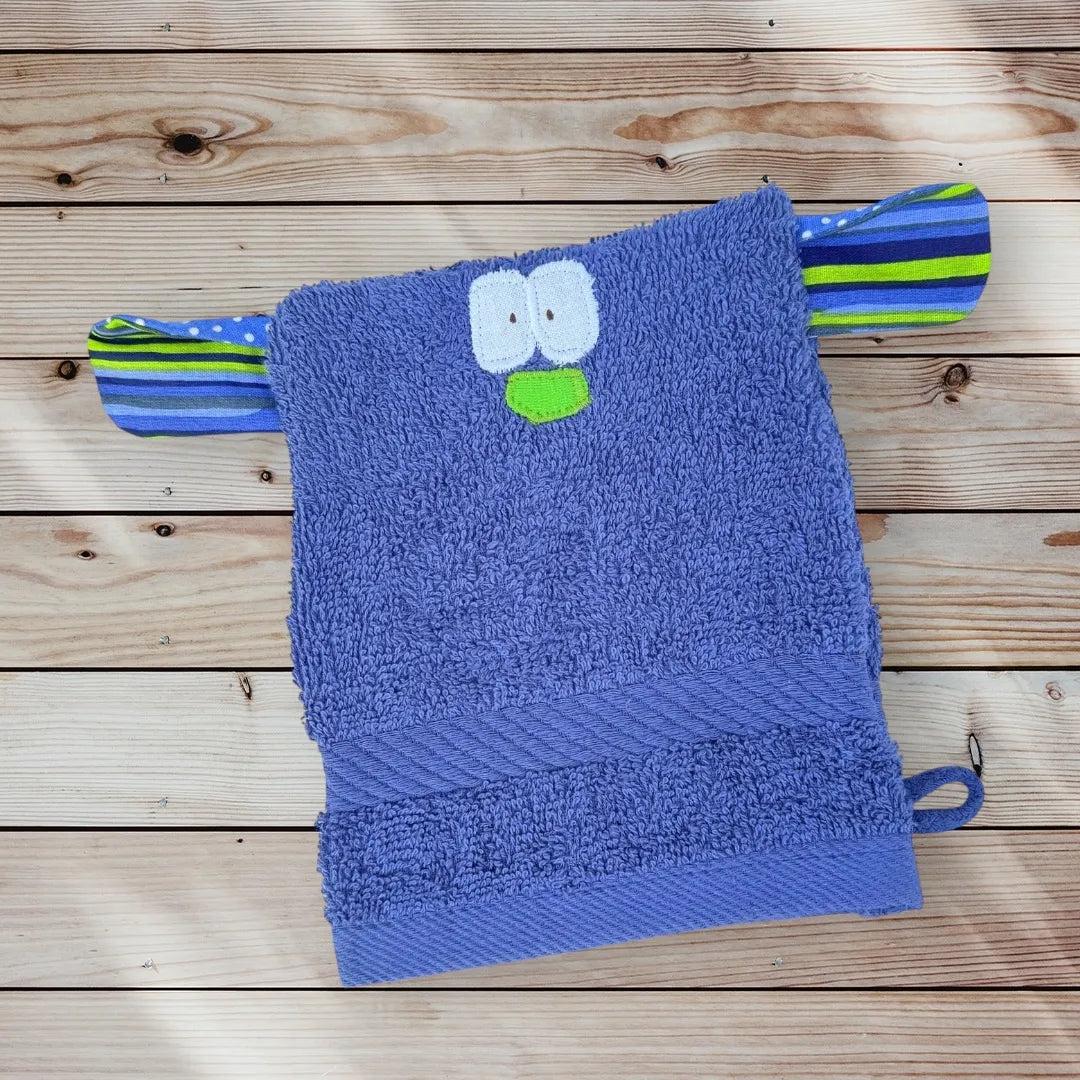 Blauer Waschhandschuh in Form eines lustigen Monsterchens mit großen Augen, bunter Nase und bunt gemusterten großen Ohren-ideal für Kinder.