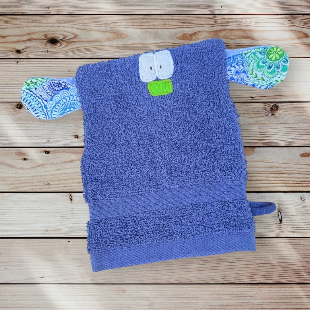 Blauer Waschhandschuh in Form eines lustigen Monsterchens mit großen Augen, bunter Nase und bunt gemusterten großen Ohren-ideal für Kinder.