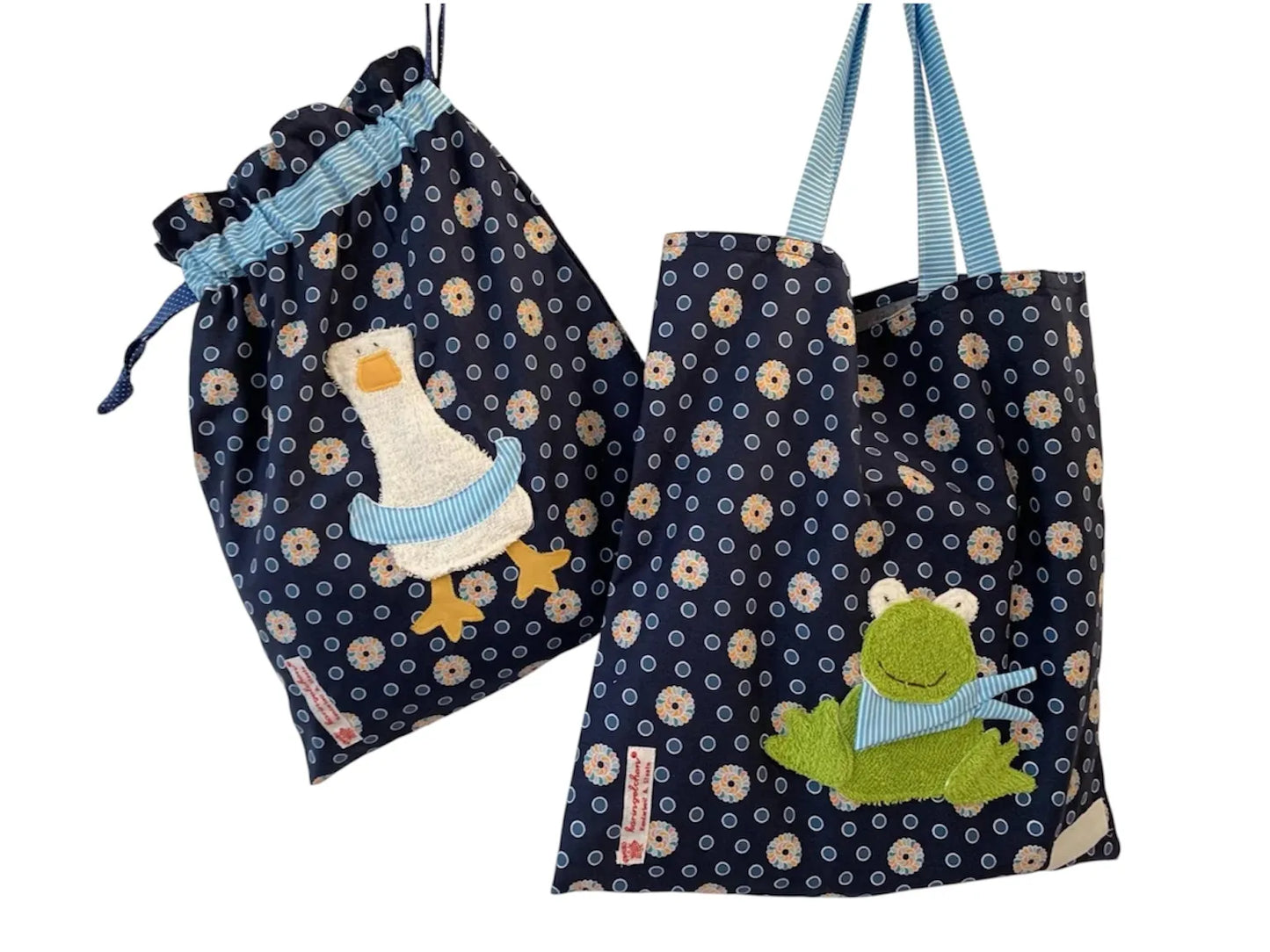 Handgemachtes Kita-Set bestehend aus einem blauen Wetbag mit Entenmotiv einem passenden Garderobenbeutel mit Froschapplikation-beide aus geblümten Stoff mit bunten Details