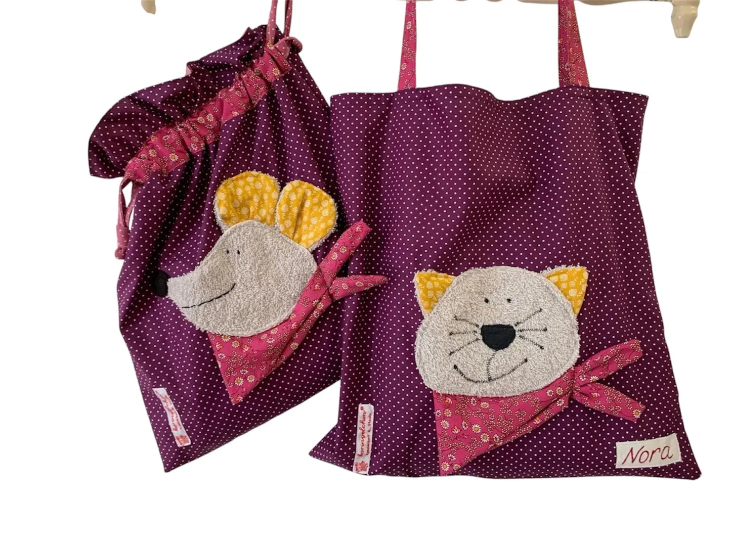 Handgemachtes Kita-Set bestehend aus einem dunkellila Wetbag mit Mausmotiv und einem passenden Garderobenbeutel mit Katzenapplikation- beide aus gepunkteten Stoff mit bunten Details