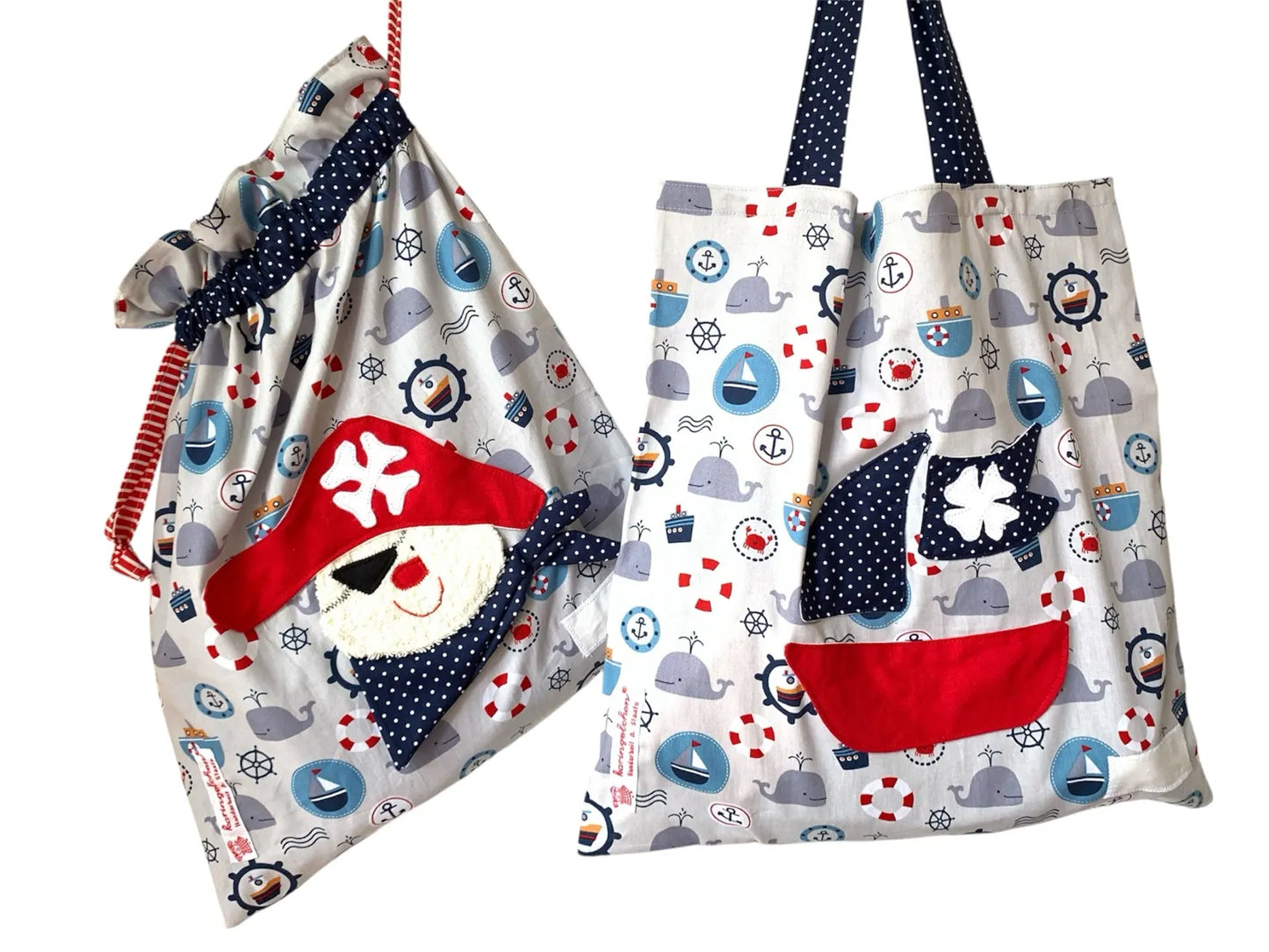 Handgemachtes Kita-Set bestehend aus einem grauen Wetbag mit Piratenmotiv und einem passenden Garderobenbeutel mit Piratenboot - beide aus Stoff mit maritimen Details