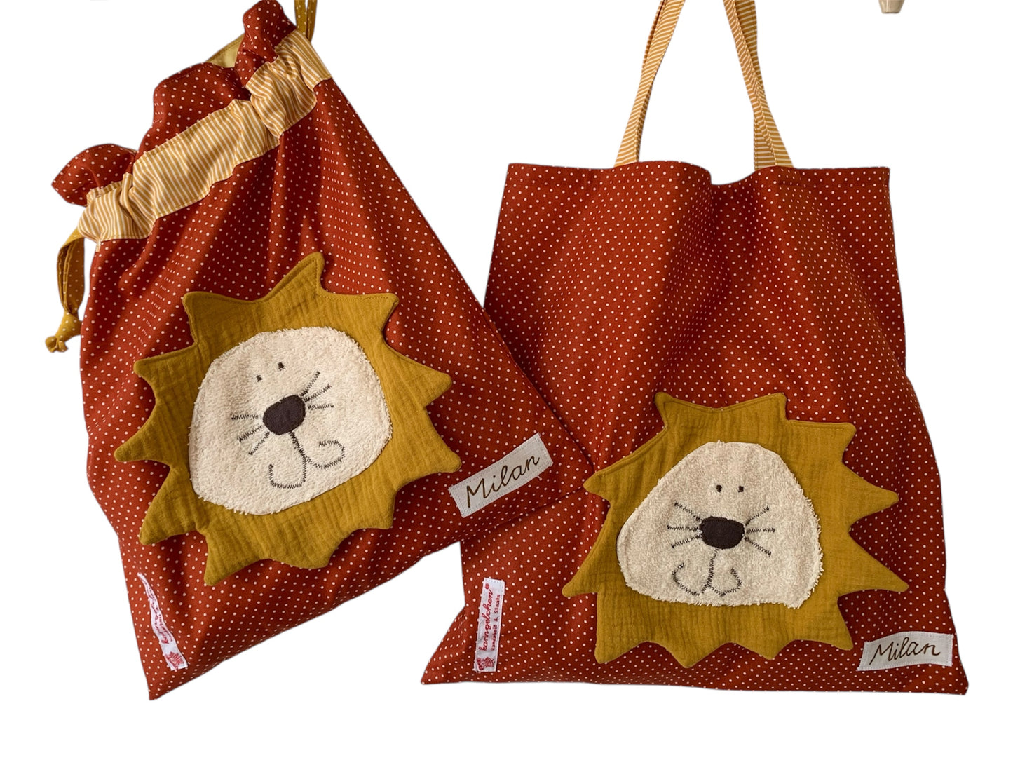 Handgemachtes Kita-Set bestehend aus einem terrakottafarbenen Wetbag mit Löwen und einem passenden Garderobenbeutel mit Löwe beide aus gepunkteten Stoff mit bunten Details