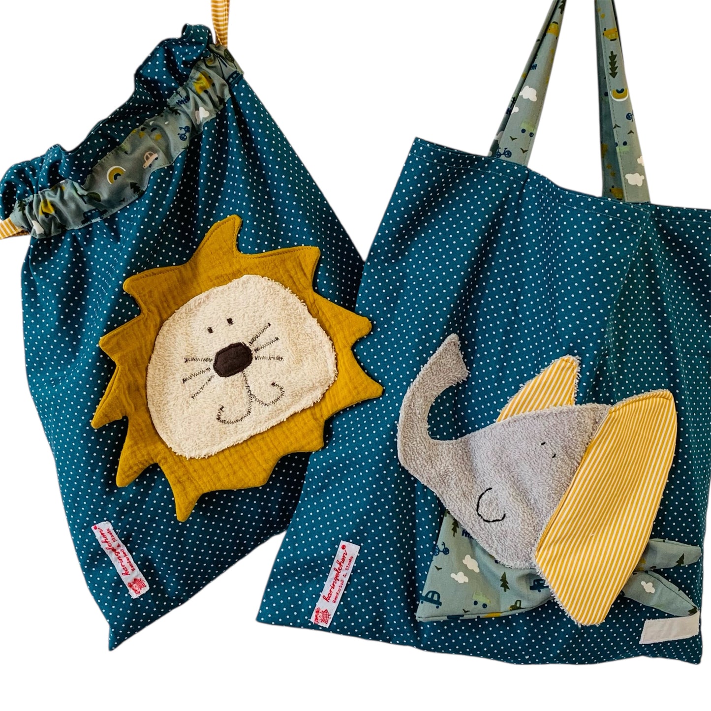 Handgemachtes Kita-Set bestehend aus einem petrolfarbenen Wetbag mit Löwenmotiv und einem passenden Garderobenbeutel mit Elefantenappliaktion beide aus gepunkteten Stoff mit bunten Details