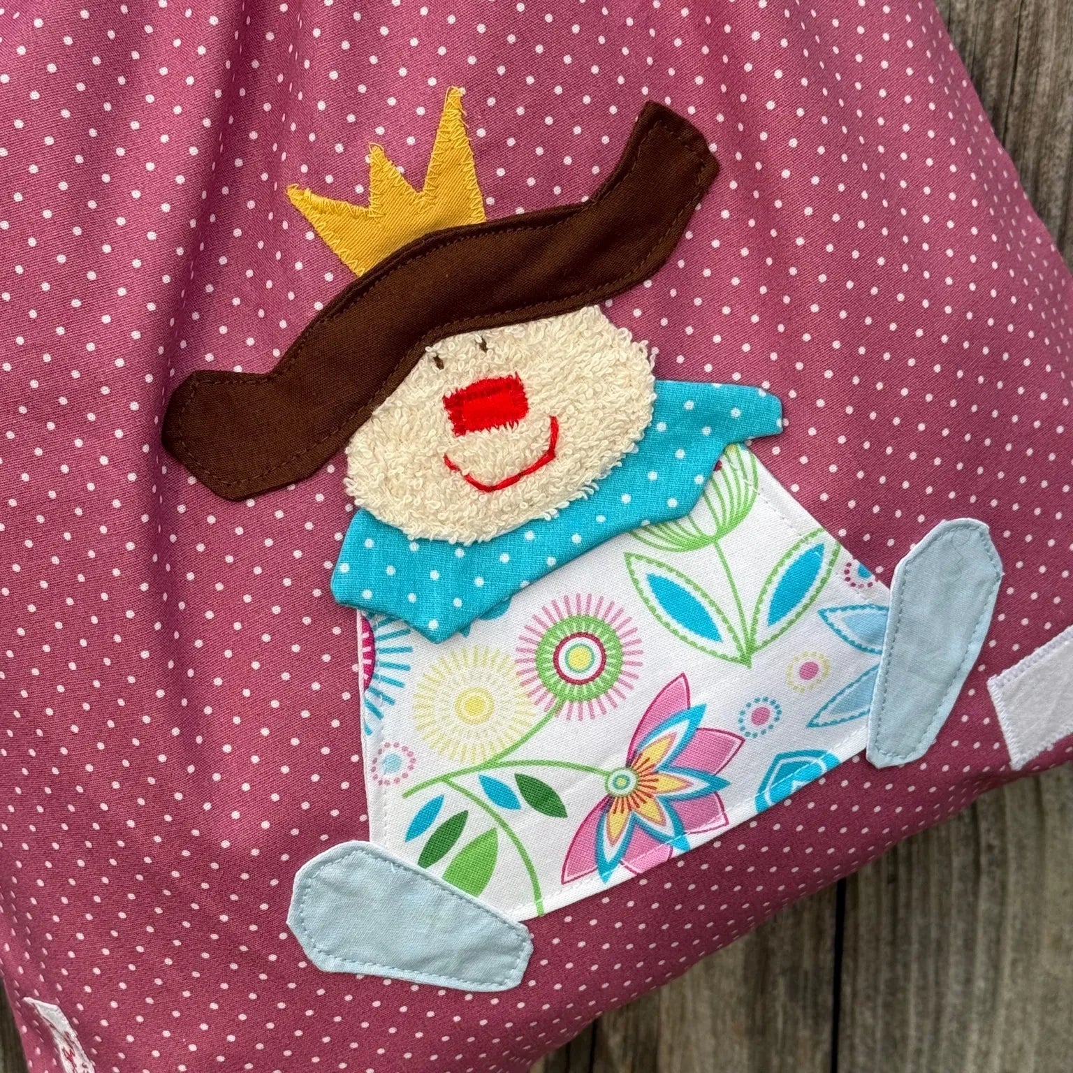 Detailaufnahme eines handgemachten Wetbags für Mädchen mit liebevoller Stofffapplikation Prinzessin mit Krone auf altrosa gepunkteten Baumwollstoff