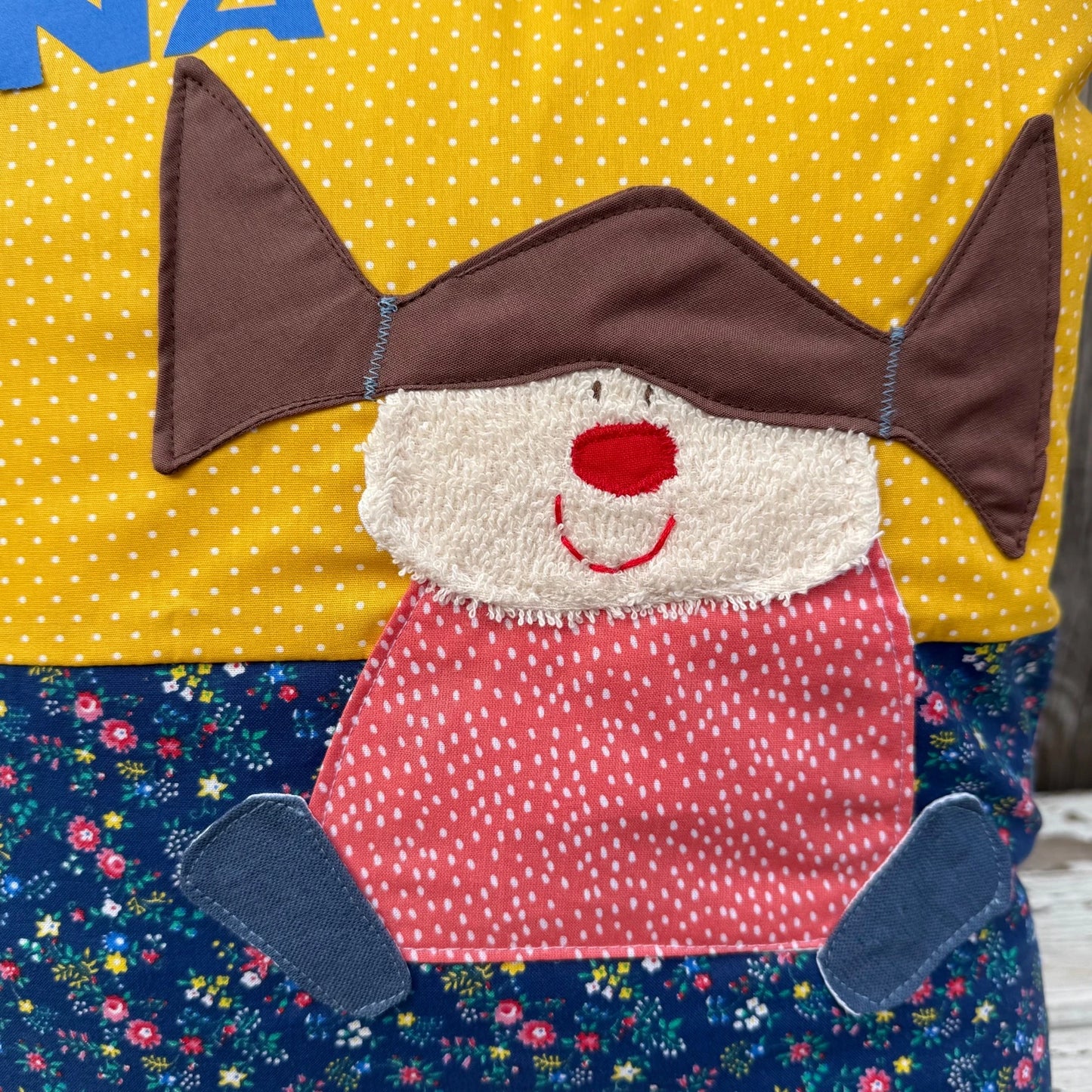 Mädchenkissen mit Zopfmädchen auf geblümter und gelb gepunkteter Baumwolle