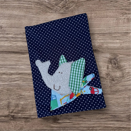 Personalisierbare U-Heft-Hülle aus dunkelblauen Stoff mit weißen Punkten , verziert mit einem fröhlichen Elefant und personalisierbar mit Namen