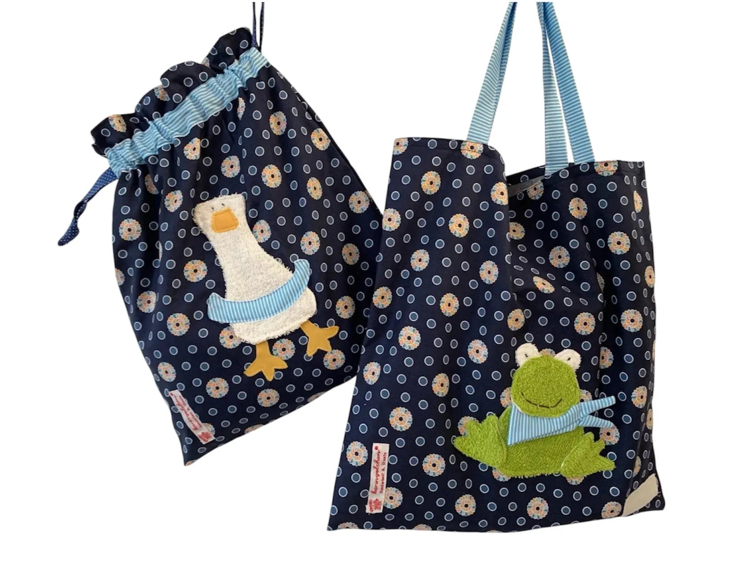 Handgemachtes Kita-Set bestehend aus einem blauen Wetbag mit Entenmotiv einem passenden Garderobenbeutel mit Froschapplikation-beide aus geblümten Stoff mit bunten Details