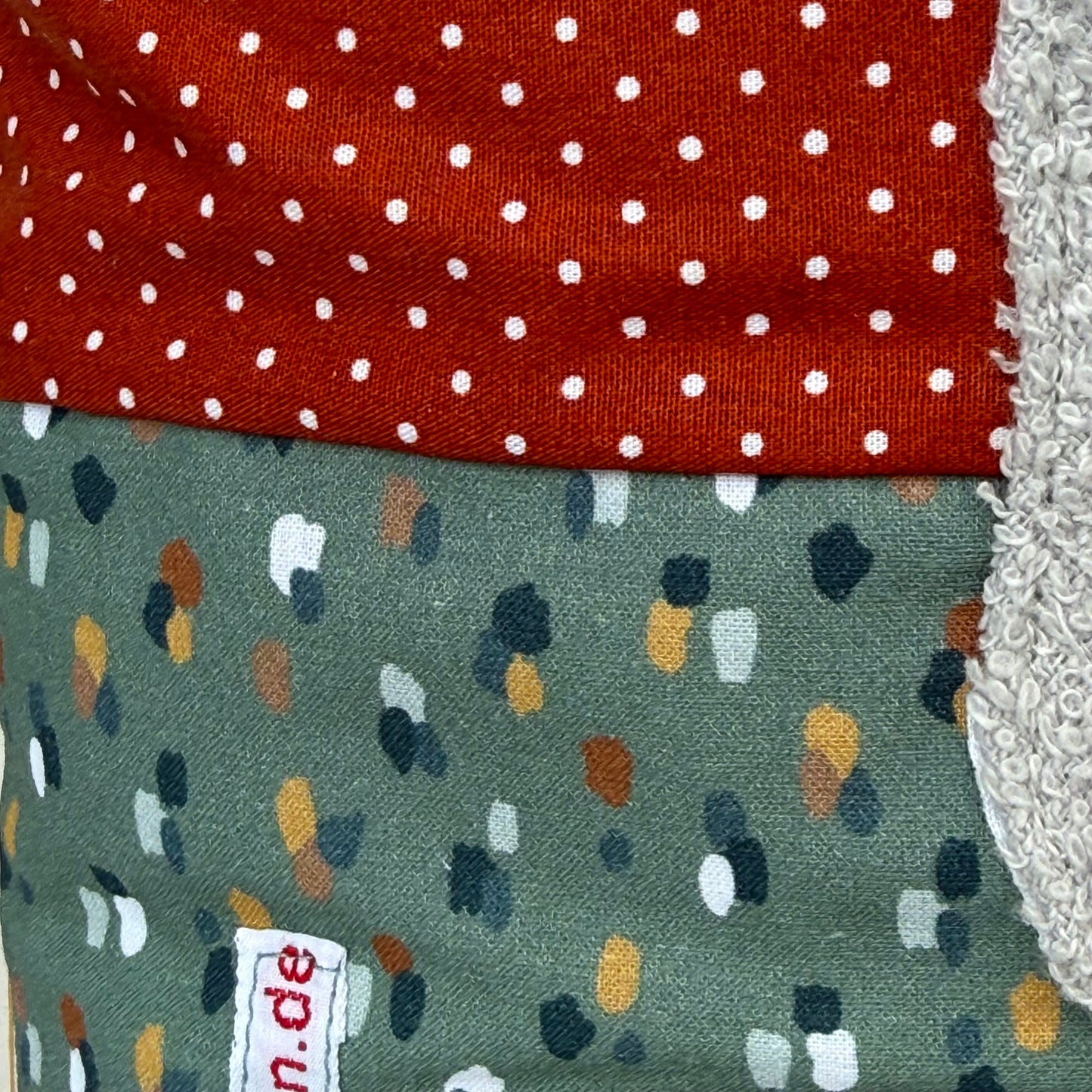Personalisiertes Kinderkissen mit Elefant und Namen, Rost rot gepunkteter Baumwollstoff und Salbei getupften Baumwollstoff mit 3D-Frottee-Applikation in Blau und Grau, handgemacht.
Nahaufnahme der Stoffkombi