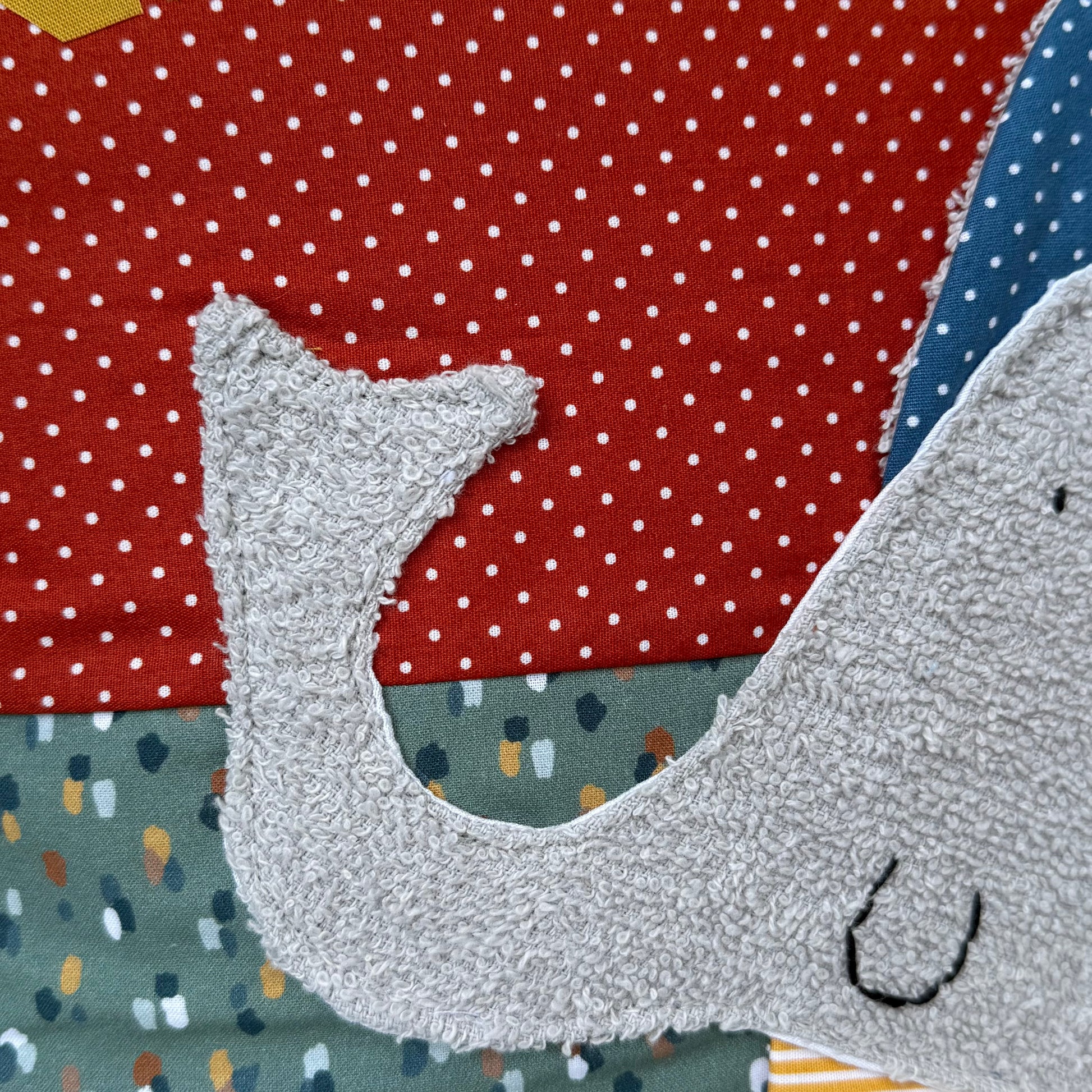 Personalisiertes Kinderkissen mit Elefant und Namen, Rost rot gepunkteter Baumwollstoff und Salbei getupften Baumwollstoff mit 3D-Frottee-Applikation in Blau und Grau, handgemacht.
Nahaufnahme des silbergrauen Frottee 