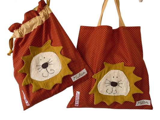 Handgemachtes Kita-Set bestehend aus einem terrakottafarbenen Wetbag mit Löwen und einem passenden Garderobenbeutel mit Löwe beide aus gepunkteten Stoff mit bunten Details