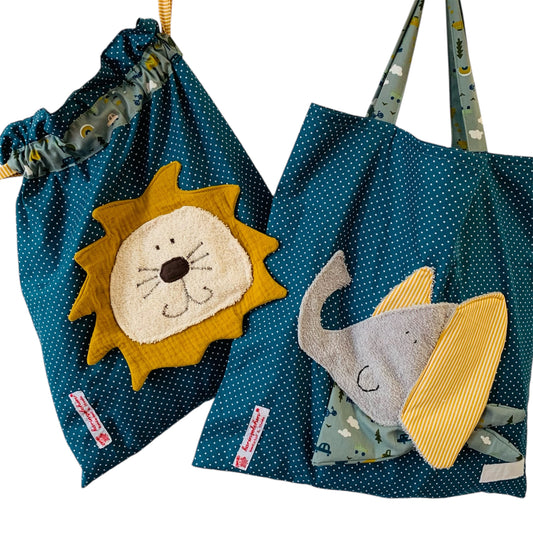 Handgemachtes Kita-Set bestehend aus einem petrolfarbenen Wetbag mit Löwenmotiv und einem passenden Garderobenbeutel mit Elefantenappliaktion beide aus gepunkteten Stoff mit bunten Details