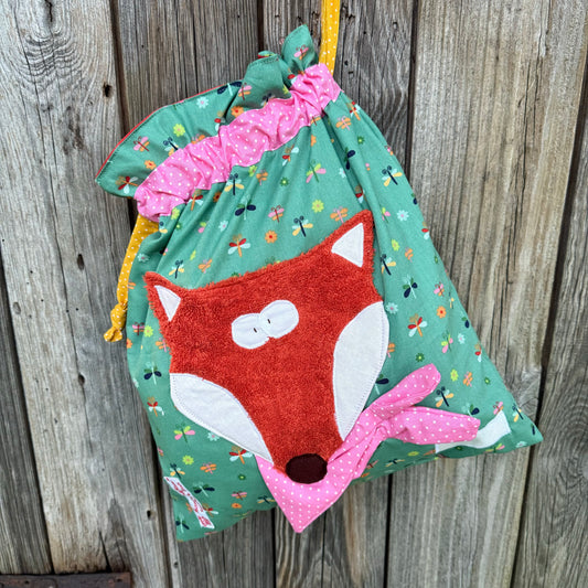 Wetbag Fuchs, Nasstasche Fuchs in grün mit Libellenprint und kuscheliger oranger Fuchsapplikation aus Frottee. Der Fuchs trägt ein rosa gepunktetes Halstuch